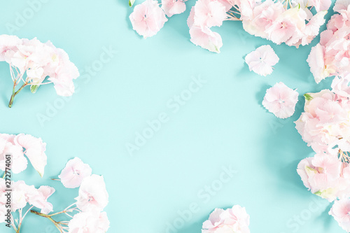 Flowers composition. Frame made of pink and white flowers on pastel blue background. Flat lay, top view, copy space, square