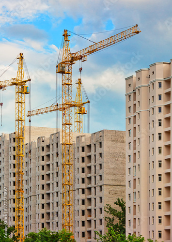 Construction site with cranes, urban background