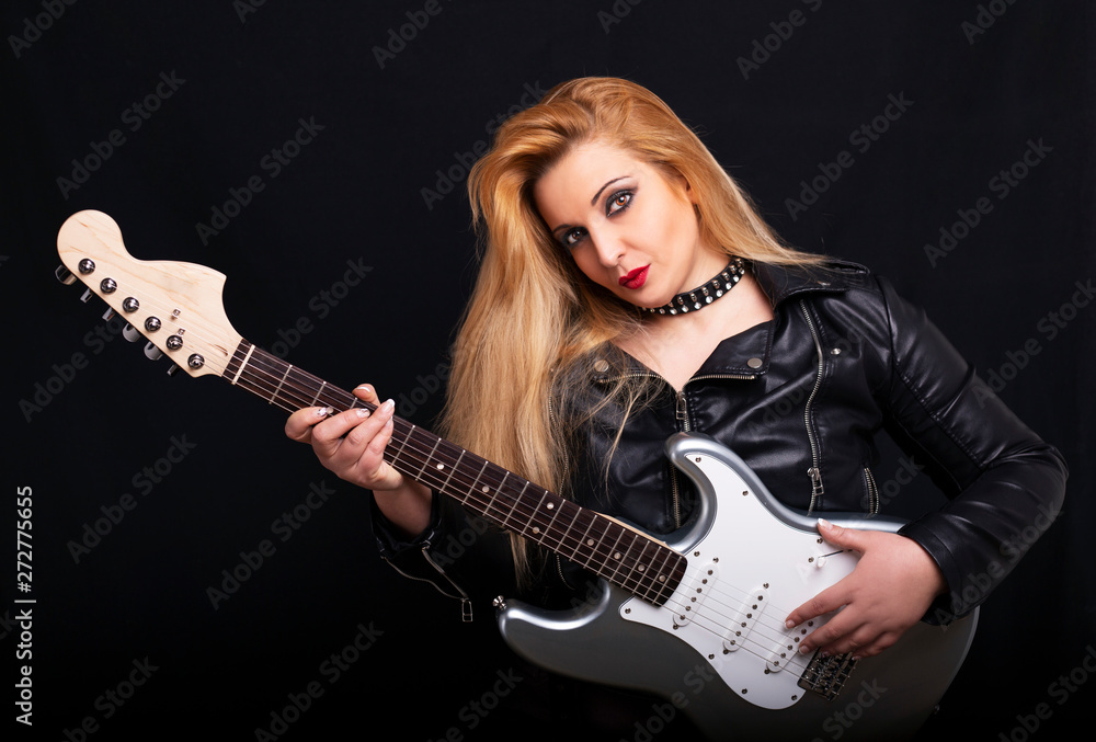 Beautiful blonde girl playing guitar in rock style on a black background. Beautiful blonde girl playing guitar in rock style on a black background.