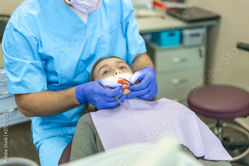 Dental clinic. Reception, examination of the patient. Teeth care. Young woman undergoes a dental examination by a dentist