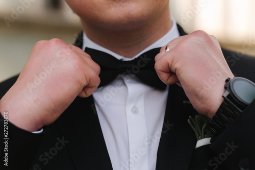 Close up of man's hand on tie bow