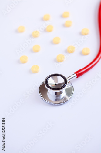 stethoscope for doctor checkup with pills on medical laboratory table