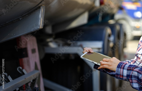 Truck drivers hand holding tablet checking the product list,Driver writing electronic log books,spot focus.