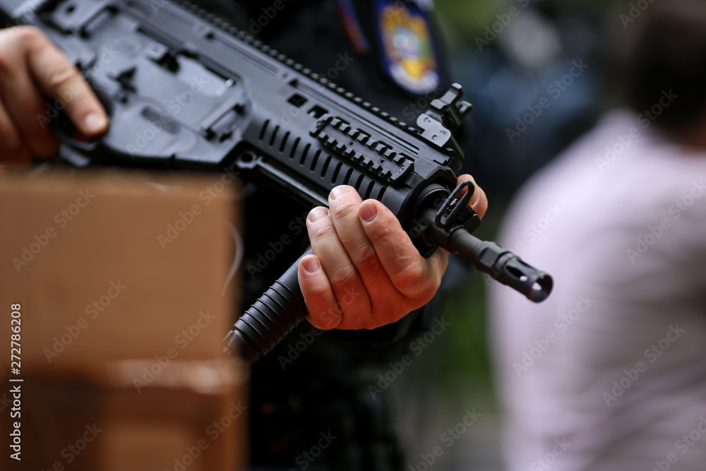 .Details with the hands of a man holding an automatic rifle. .Details with the hands of a man holding an automatic rifle.