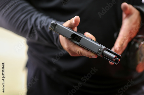 Details with the hands of a man handling a 9mm handgun