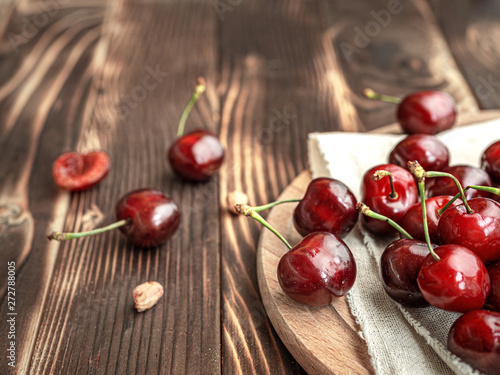Closeup summer sweet red cherries in a plate on a wooden background