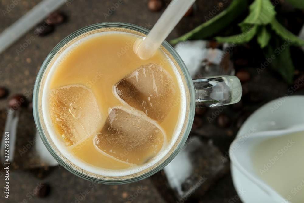 Ice latte or Iced coffee with milk and ice cubes in a glass beaker against a dark background. refreshing drink. summer drink. top view Ice latte or Iced coffee with milk and ice cubes in a glass beaker against a dark background. refreshing drink. summer drink. top view