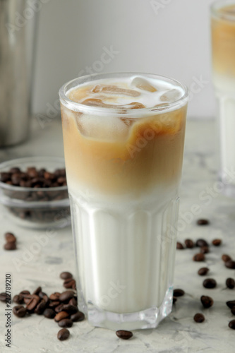 Ice latte or Iced coffee with milk and ice cubes in a glass beaker on a light background. refreshing drink. summer drink.