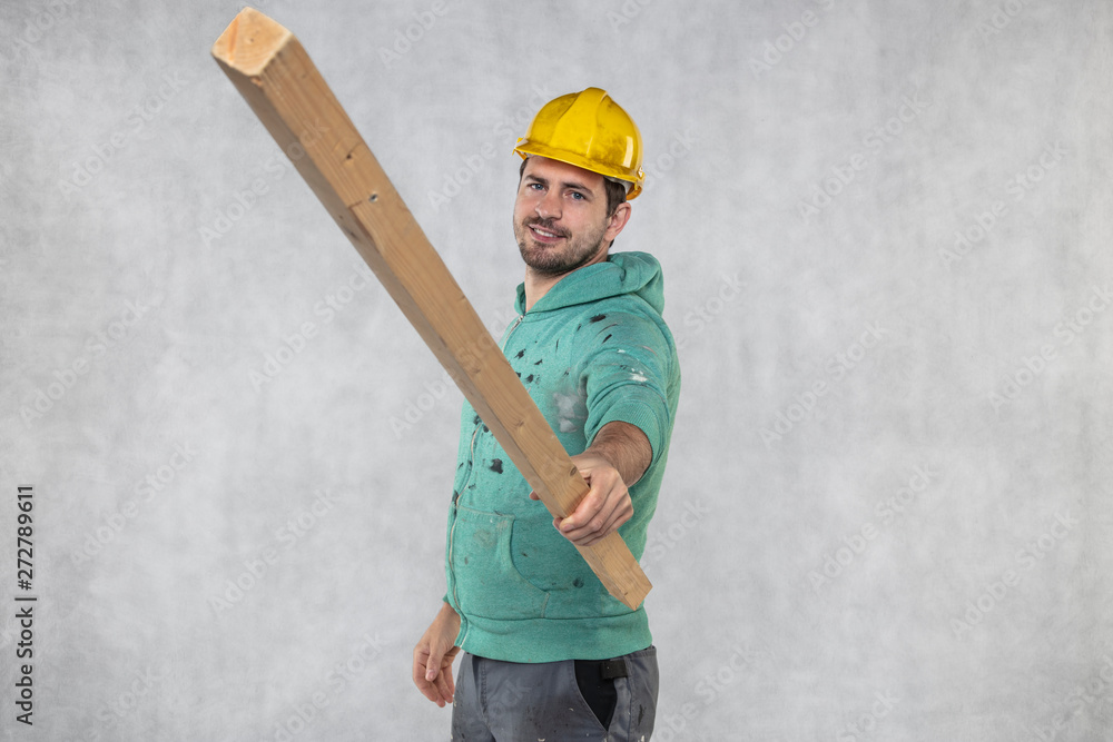 the construction worker holds a piece of board in his hands, the concept of choosing wood for construction the construction worker holds a piece of board in his hands, the concept of choosing wood for construction