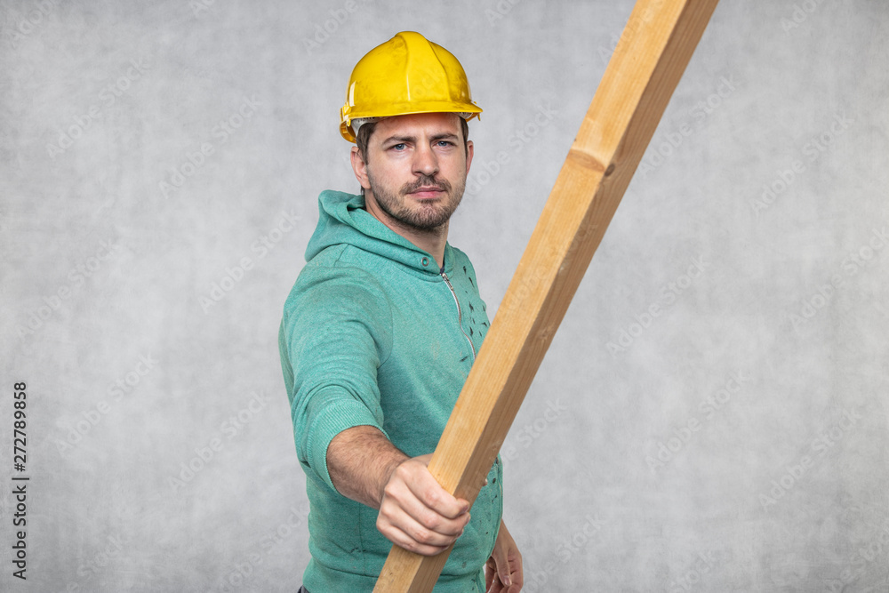 the construction worker holds a piece of board in his hands, the concept of choosing wood for construction the construction worker holds a piece of board in his hands, the concept of choosing wood for construction