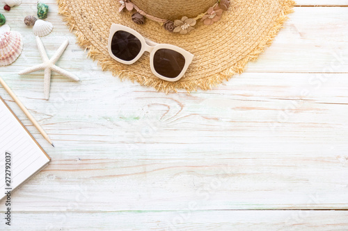 Vacation travel equipment Straw hat, sunglasses and marine objects, shells, starfish, passport on light wooden floor. Platform with copy space. Summer vacation concept.