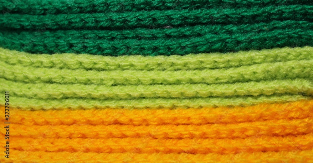 A pile of bright green and yellow knitted elements. Warm and soft wallpaper, pattern, background A pile of bright green and yellow knitted elements. Warm and soft wallpaper, pattern, background
