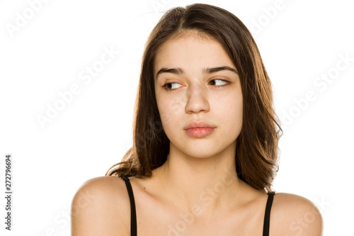 Young beautiful woman without makeup looking aside on white background