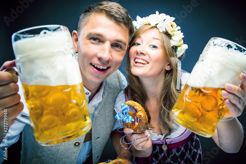 Two friends, men and women, having clinking glasses with Bavarian beer