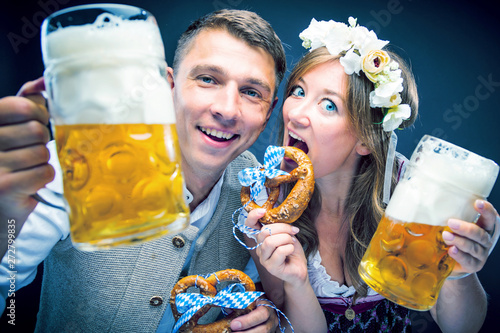 Two friends, men and women, having clinking glasses with Bavarian beer