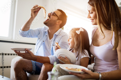 Portrait of happy family sharing pizza at home