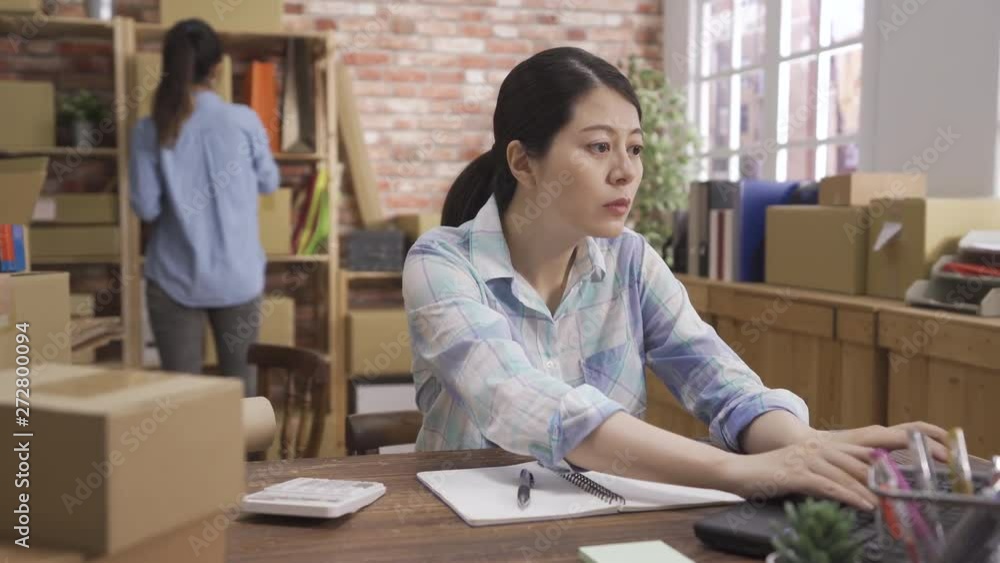 Young asian entrepreneur partners business owners work at home office checking customer order together. Retail wholesale small business or SME concept with cardboard boxes. girls workers discussing. Young asian entrepreneur partners business owners work at home office checking customer order together. Retail wholesale small business or SME concept with cardboard boxes. girls workers discussing.