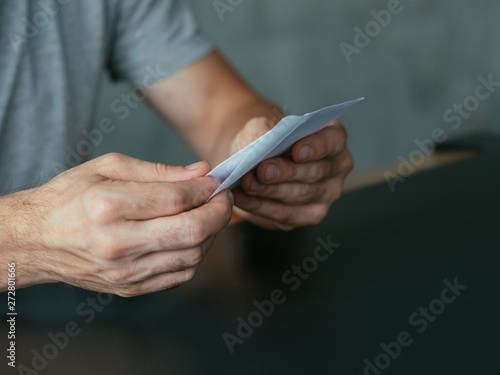 Business correspondence. Cropped shot of man opening envelope with letter. Copy space.