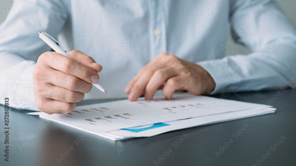 Business analysis. Cropped shot of man working with graphs and charts. Blur background. Business analysis. Cropped shot of man working with graphs and charts. Blur background.