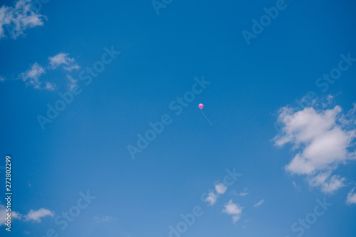 Multicolored balloons against the blue sky and clouds. Last call and graduation at school