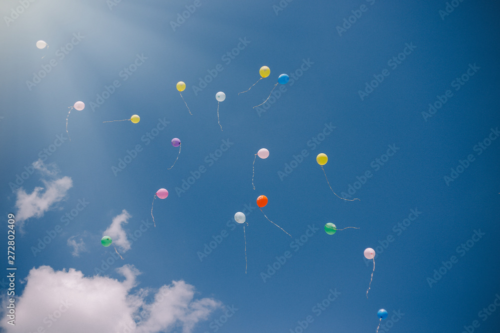 Multicolored balloons against the blue sky and clouds. Last call and graduation at school Multicolored balloons against the blue sky and clouds. Last call and graduation at school