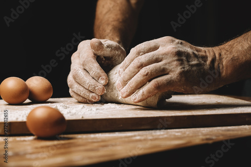 Billede på lærred Beautiful and strong men's hands knead the dough from which they will then make bread, pasta or pizza