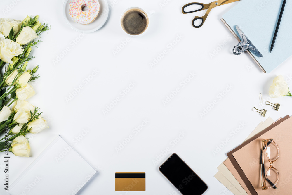 top view of flowers, cup of coffee, credit card, doughnut, scissors, clipboard, glasses, craft paper and book on white top view of flowers, cup of coffee, credit card, doughnut, scissors, clipboard, glasses, craft paper and book on white