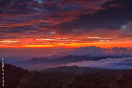 sunrise at Doi Inthanon, Km. 41 view point, mountain view misty morning on top hill with sea of mist in valley and red sun light in the sky background, Chiang Mai, Thailand. © Yuttana Joe
