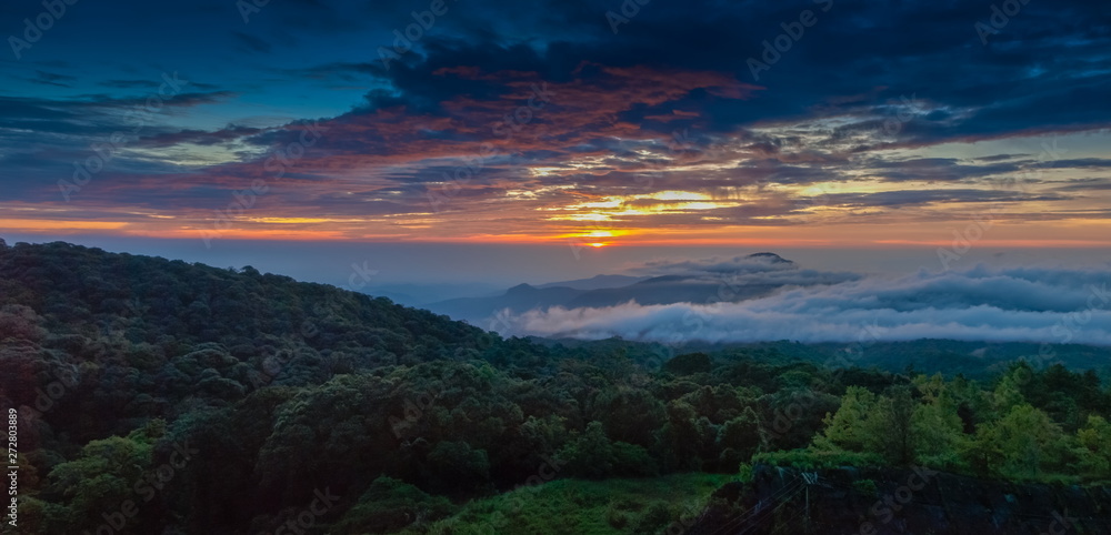 sunrise at Doi Inthanon, Km. 41 view point, mountain view misty morning on top hill panorama 180 degrees with sea of mist in valley and red sun light in the sky background, Chiang Mai, Thailand.