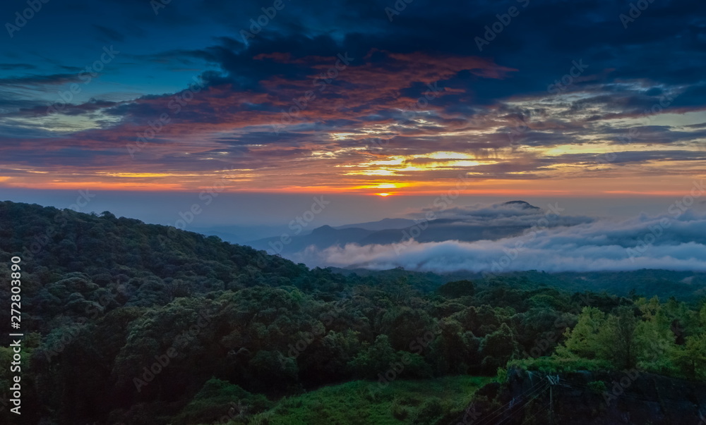 sunrise at Doi Inthanon, Km. 41 view point, mountain view misty morning on top hill panorama 180 degrees with sea of mist in valley and red sun light in the sky background, Chiang Mai, Thailand.
