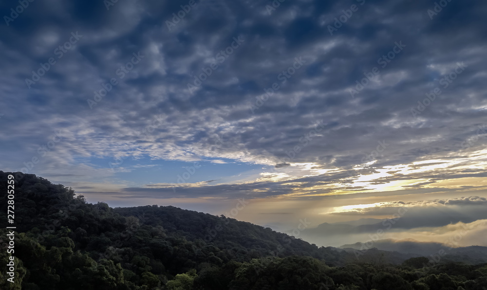 Panorama The eye of clouds shape heart, view center of Stratocumulus clouds shape heart above top hill with yellow sun light in the sky background, sunrise at Doi Inthanon, Chiang Mai, Thailand.