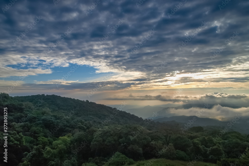 The eye of clouds shape heart, view center of Stratocumulus clouds shape heart above top hill with yellow sun light in the sky background, sunrise at Doi Inthanon, Chiang Mai, Thailand.