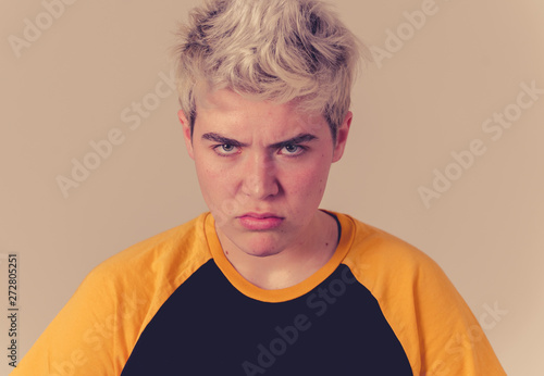 Portrait of a young transgender teenager boy with angry face looking furious. photo