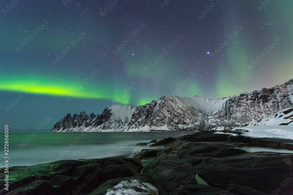 Northern lights with the ocean at a time of winter in the Lofoten Islands