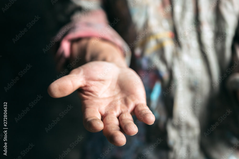 Male beggar hands seeking money, coins from human kindness on the wooden floor at public path way or street walkway. Homeless poor in the city. Problems with finance, place of residence. Male beggar hands seeking money, coins from human kindness on the wooden floor at public path way or street walkway. Homeless poor in the city. Problems with finance, place of residence.