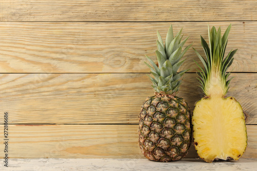 Fresh ripe pineapple halves on natural wooden background. summer. fruits.