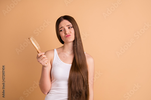 Portrait of her she nice-looking gorgeous attractive well-groomed bored tired exhausted lady combing hair nourishing effect repair keratin salon procedure restoration isolated on beige background