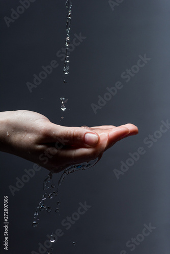 cropped view of woman with water drops on dark