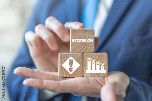 Recession market finance business concept on wooden cubes pyramid in businessman hands.