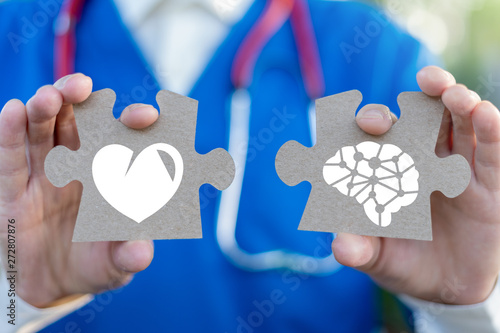 Doctor holds puzzle pieces with heart and brain. Love against mind. Conflict emotions and rational thinking. Balance irrational love and reason. Psychology Medicine concept. Problems in relation.