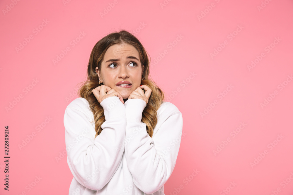 Scared woman wearing in casual clothes holding arms near chin Scared woman wearing in casual clothes holding arms near chin