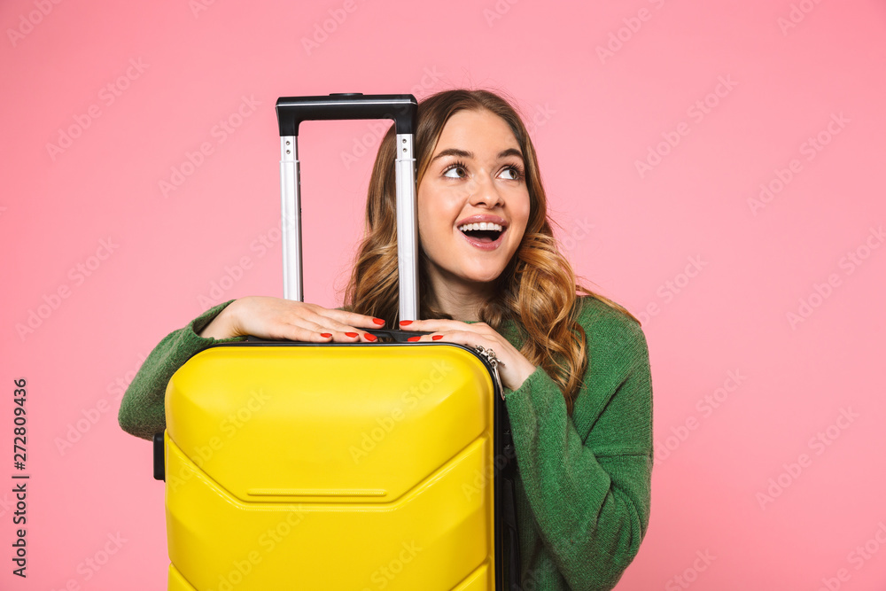 Pleased blonde woman wearing in green sweater posing with baggage - obrazy, fototapety, plakaty 