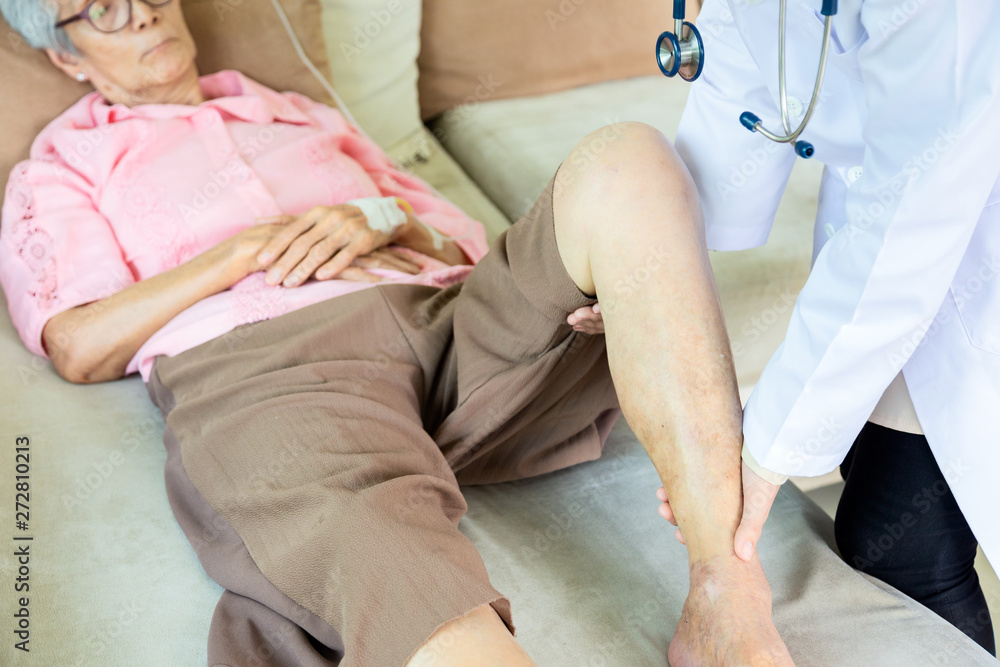 Medical asian doctor or nurse checking knee of senior patient in hospital or home,elderly woman receiving massage by female physic therapist of her leg due to injury,healthcare,support,checkup concept Medical asian doctor or nurse checking knee of senior patient in hospital or home,elderly woman receiving massage by female physic therapist of her leg due to injury,healthcare,support,checkup concept