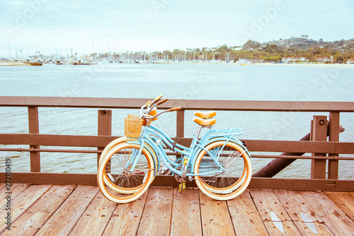 Santa Barbara romantic concept on sea, beach, yacht club panorama background. Two retro bicycles standing on Santa Barbara pier, California, USA. Vintage filter with muted teal blue and orange colors. photo