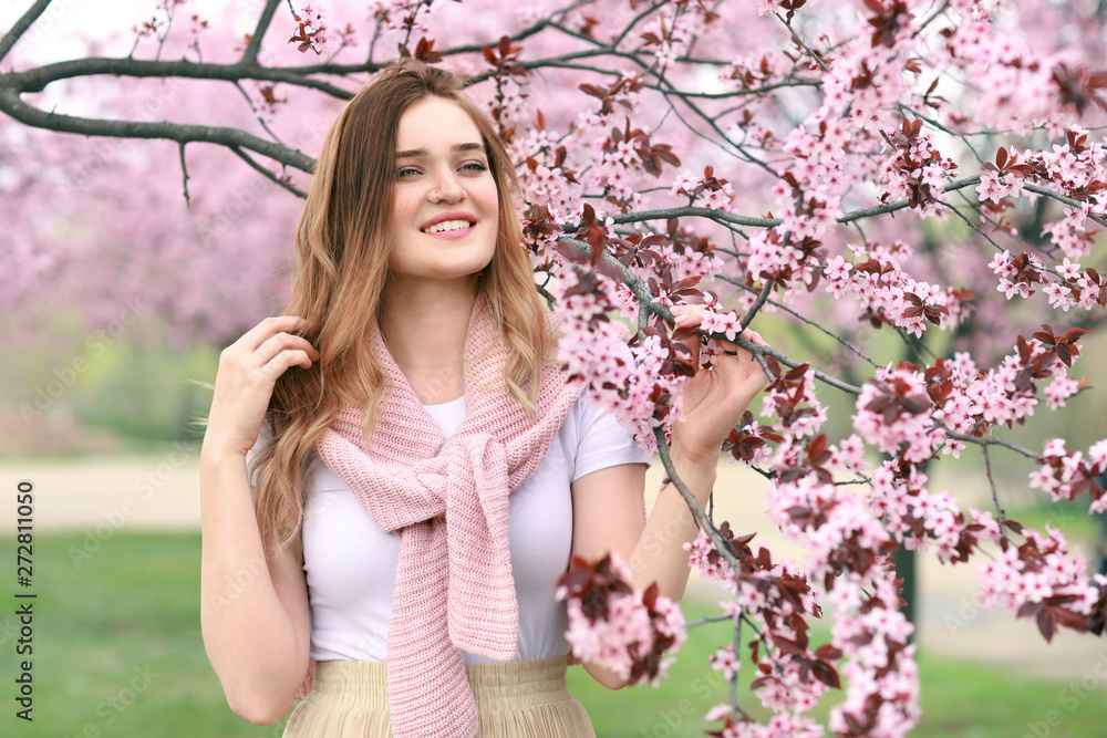 Beautiful young woman near blossoming tree on spring day Beautiful young woman near blossoming tree on spring day