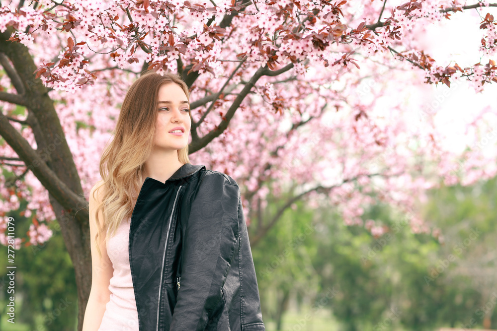 Beautiful young woman near blossoming tree on spring day Beautiful young woman near blossoming tree on spring day