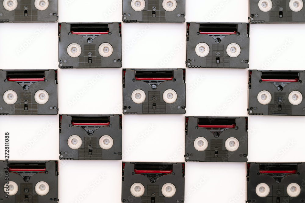 Obraz premium Vintage mini DV cassette tapes used for filming back in a day. Pattern made of plastic video tapes on white background