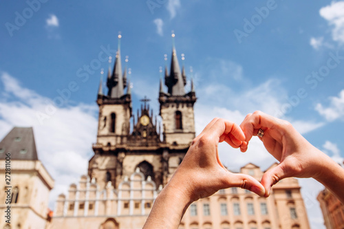 Photography Girl showing heart shape love symbol over cityscape, Tyn Church