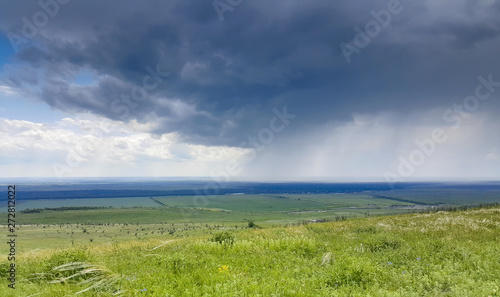 Fototapeta Naklejka Na Ścianę i Meble -  Beautiful summer rural landscape before a thunderstorm, against the blue sky.