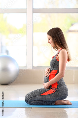 Beautiful pregnant woman training in gym